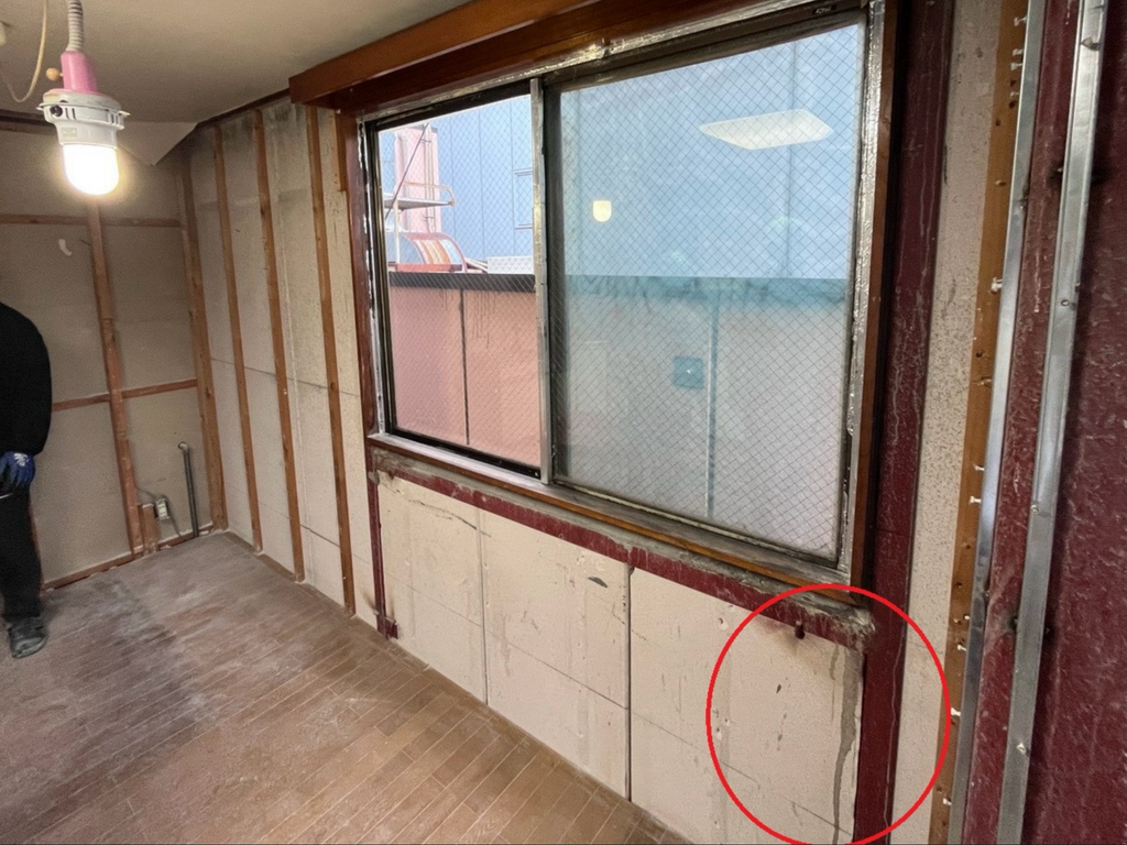 躯体が剥き出しの室内の写真。一部壁に水が滲んでいるように見えており、そこに赤丸がしてある